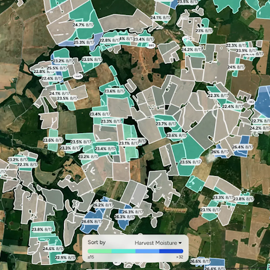 AGMRI map view of dozens of corn fields across a region, each outlined and labeled with its predicted grain moisture percentage and date. Fields are shaded on a green-to-blue scale by moisture level, with a "Sort by Harvest Moisture" legend ranging from ≤15% to >32%.